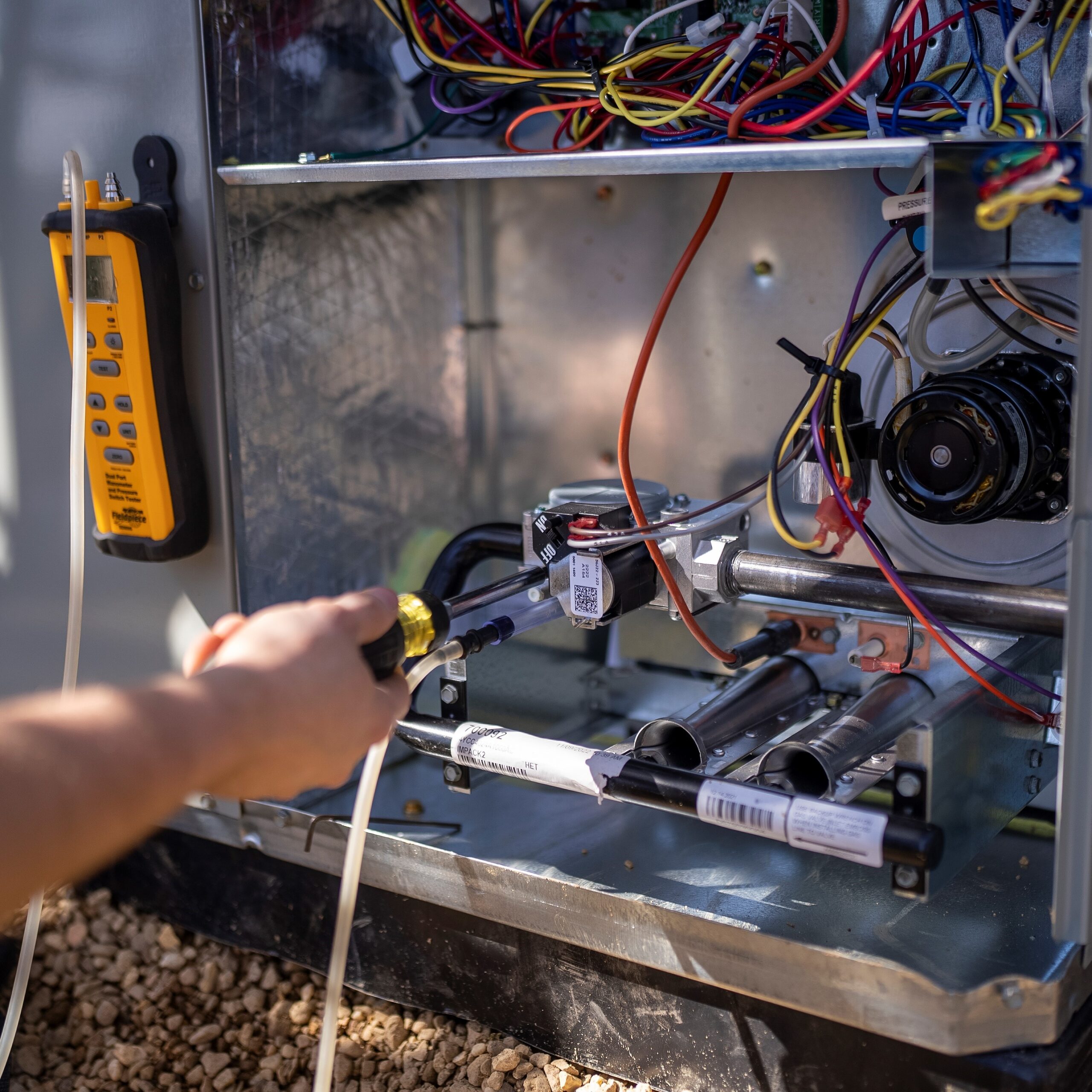 Technician using screwdriver while working on heat pump