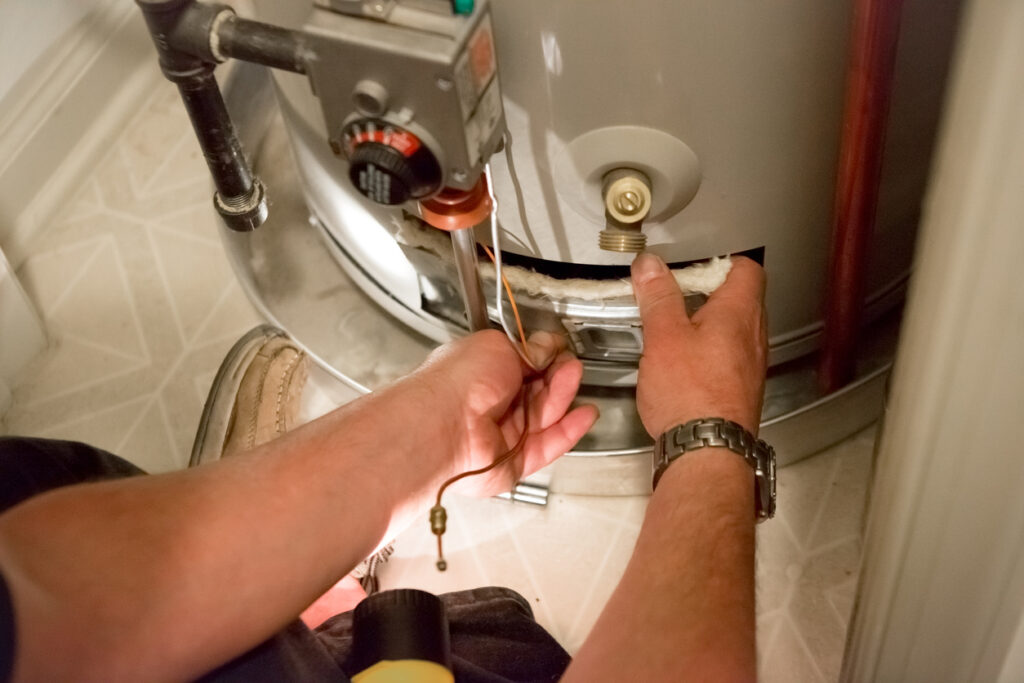 Man kneeling on the floor to work on a water heater