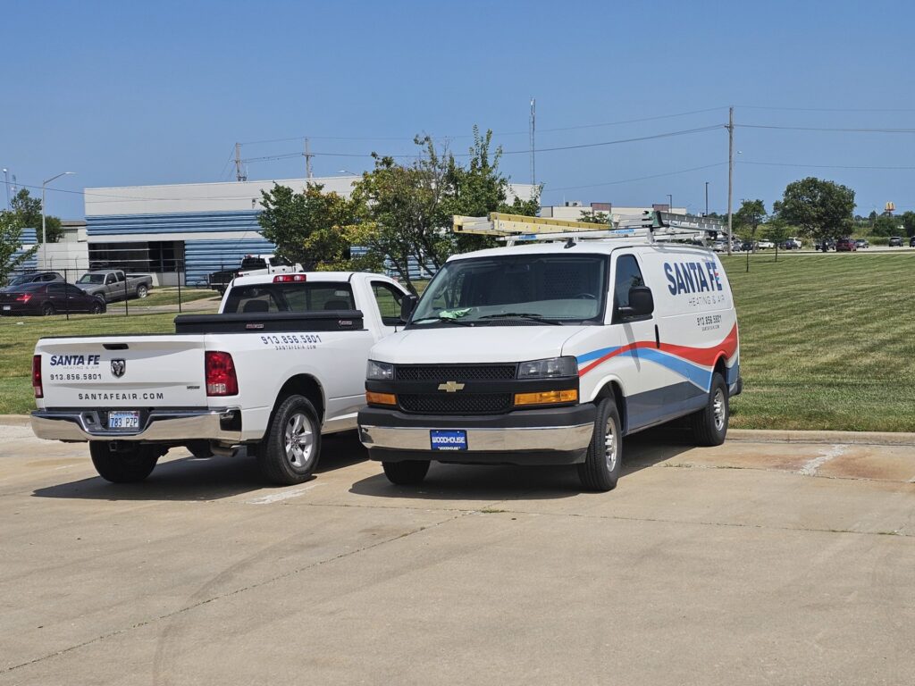 Two Santa Fe Heating & Air service vehicles parked next to each other